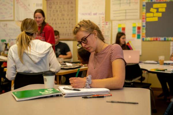 Students taking notes in an education classroom